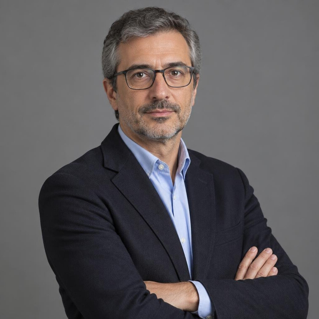 Studio portrait of a Portuguese male journalist in his forties with glasses